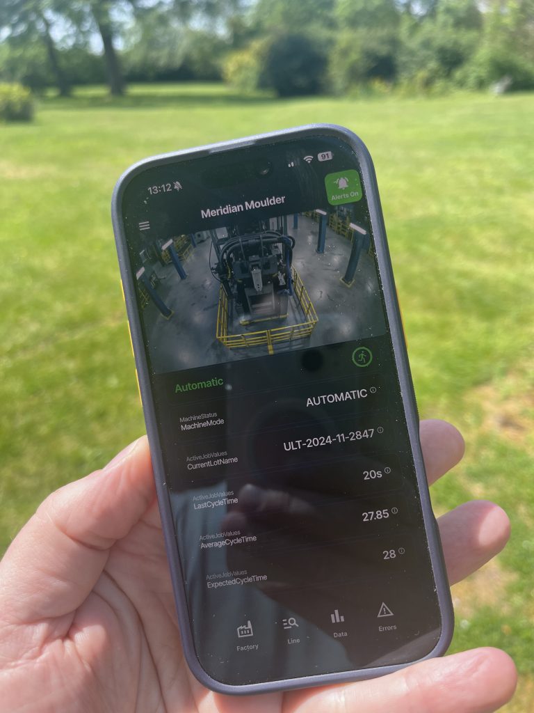the robovigil app, in someones hand showing an injection moulding machine
